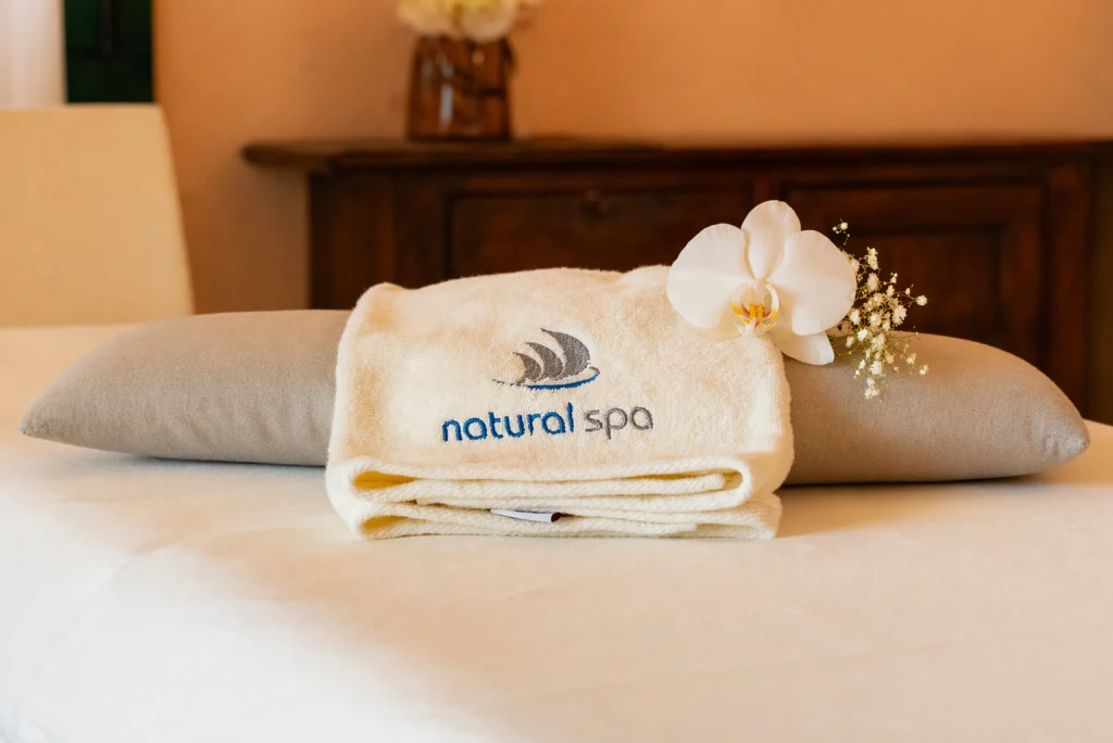 Asciugamano natural spa con cuscino e lettino da centro benessere